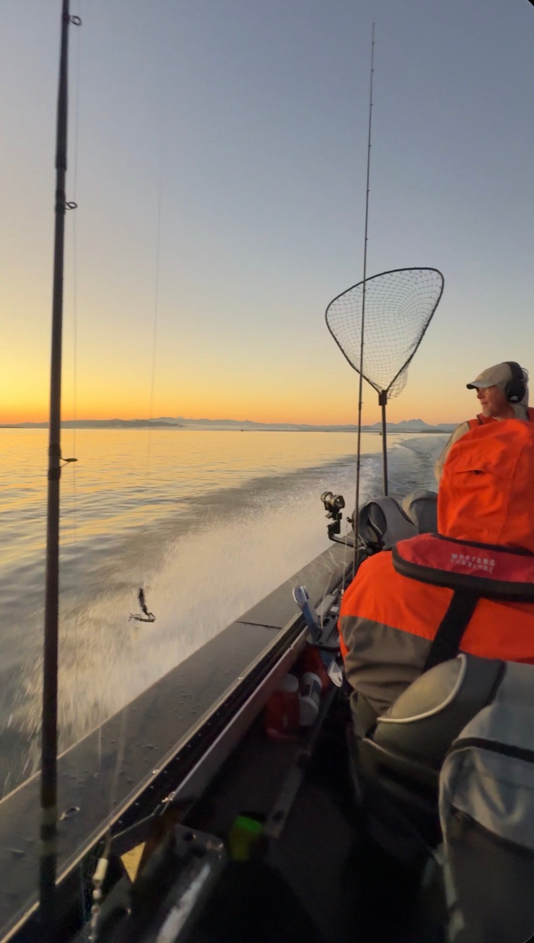 Sunrise run across calm water from the boat with rods and net rigged