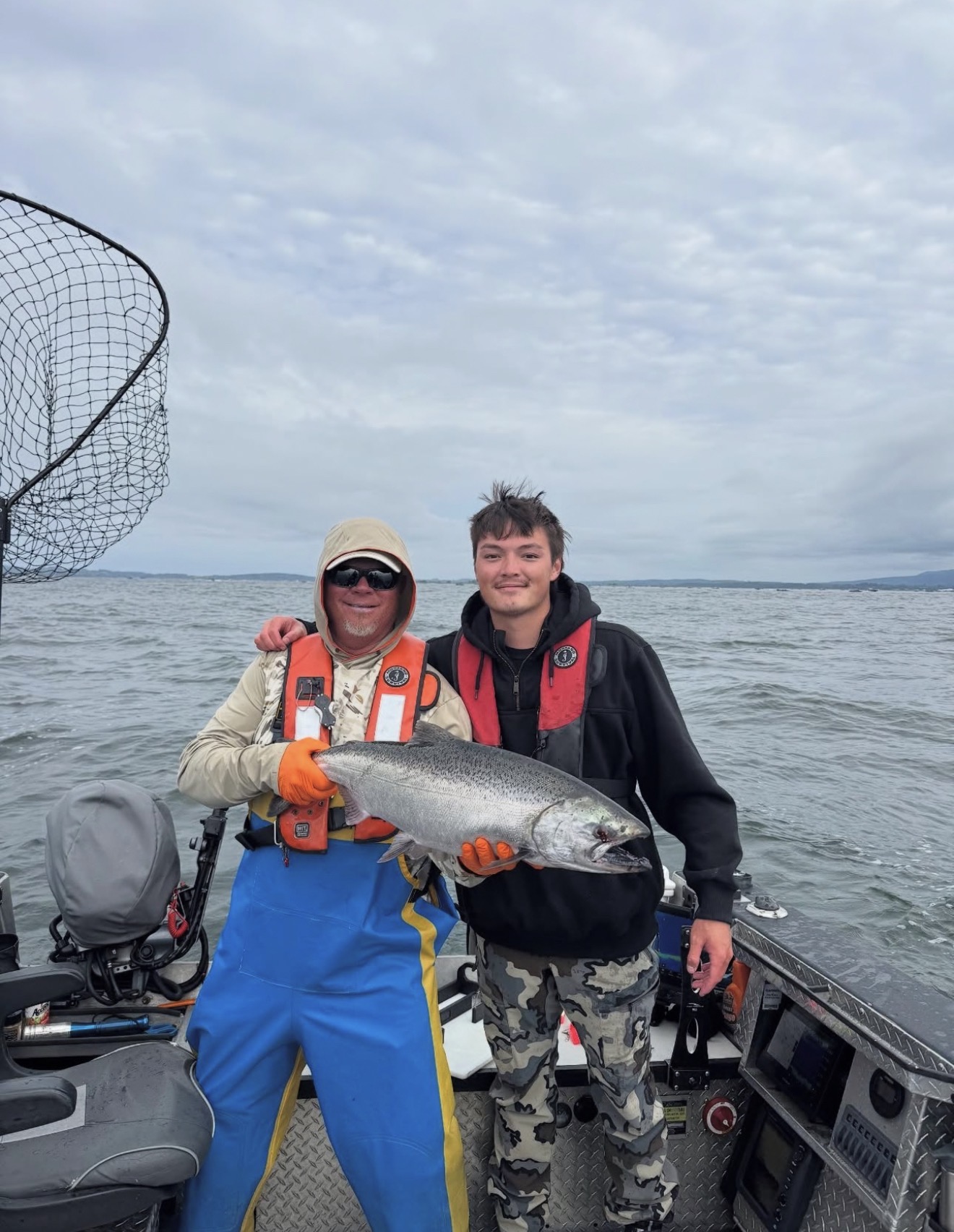 Captain Judd and a client holding a bright Chinook offshore
