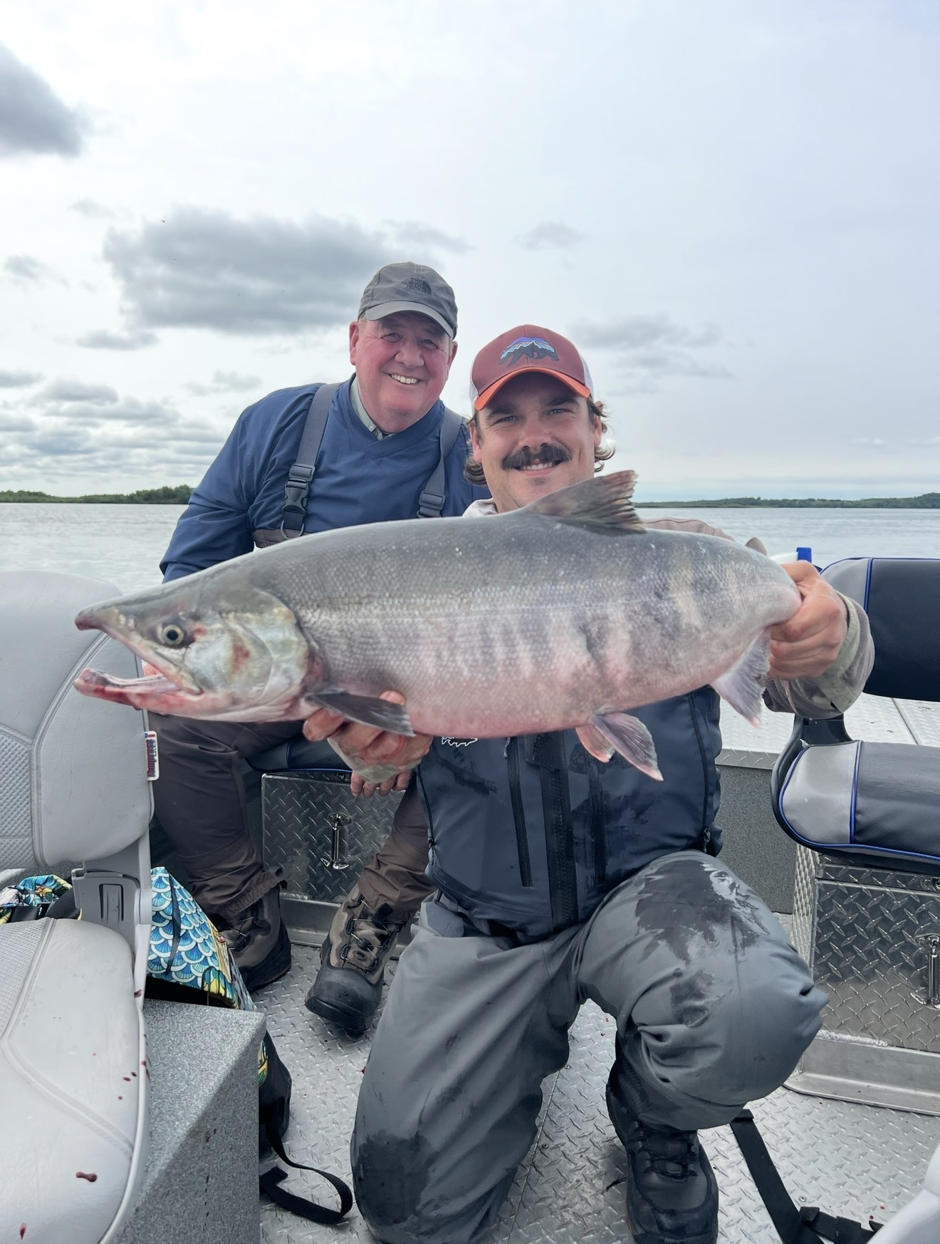 Captain Judd and a client on the boat holding a large chum salmon