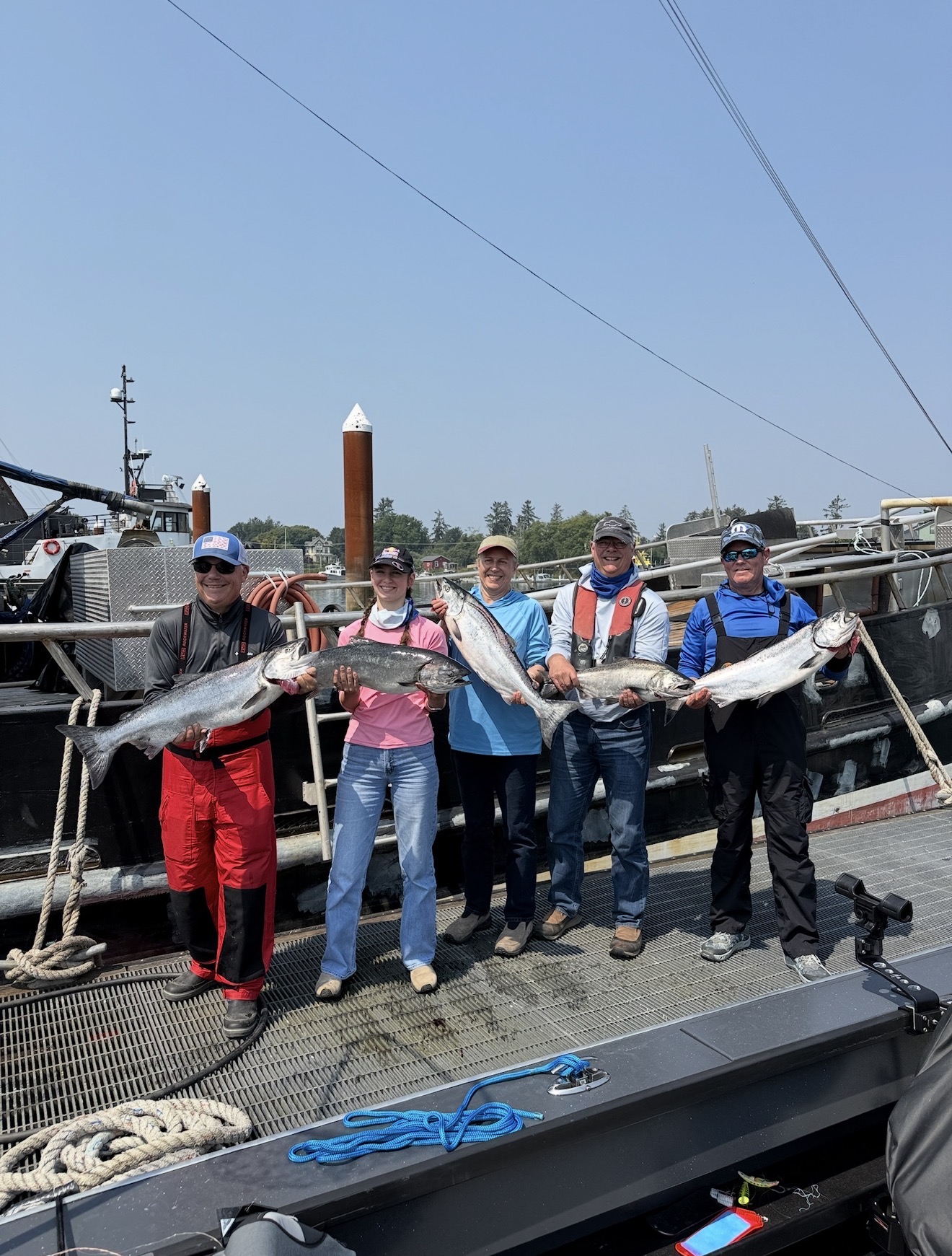 Group of five anglers on the boat showing off their limit of chrome Chinook salmon in Astoria