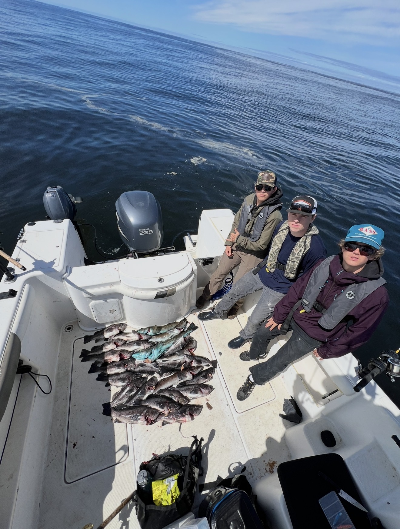Three anglers on the ocean boat with a limit of rockfish and lingcod