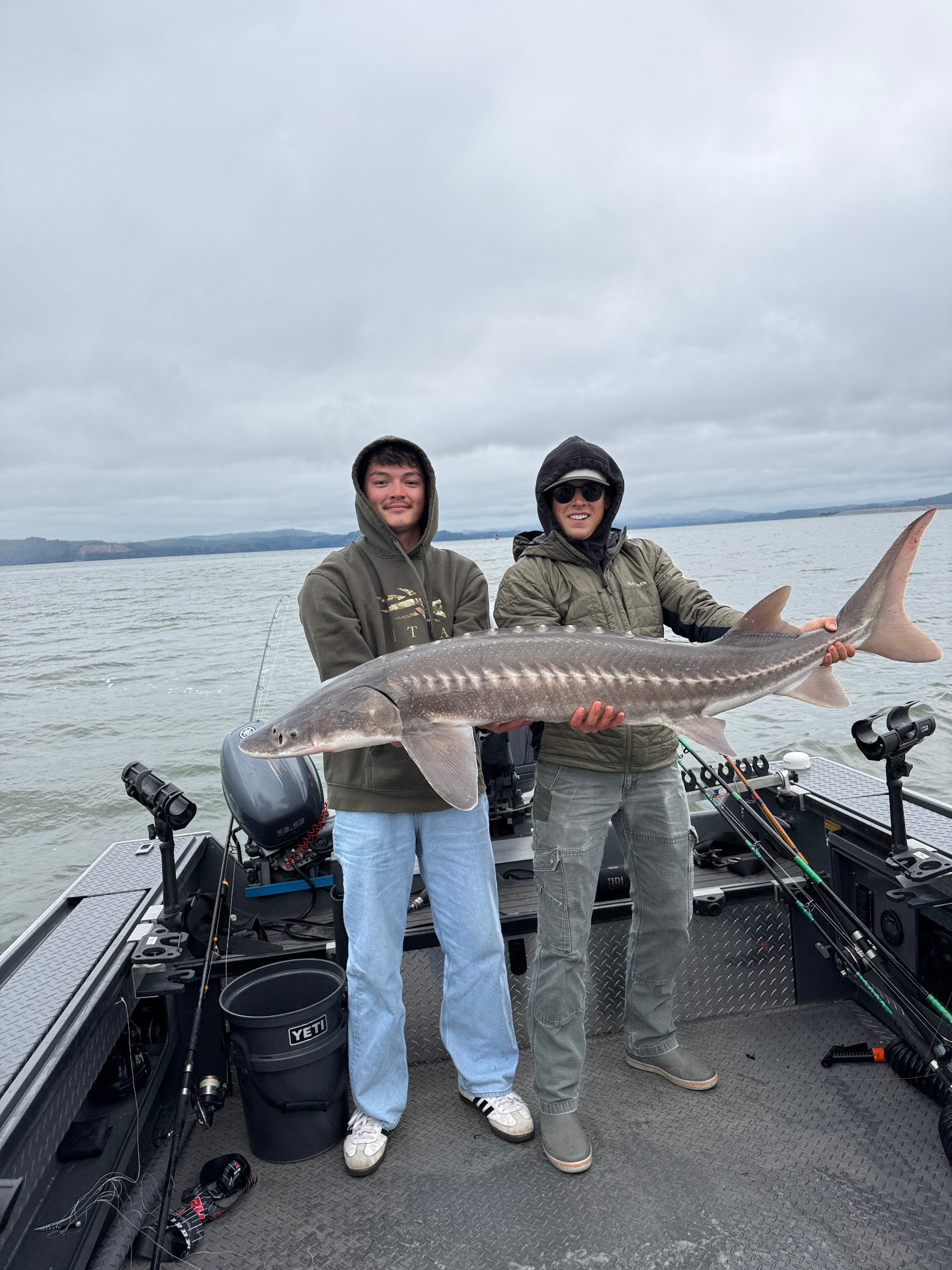 Two anglers holding a massive prehistoric sturgeon on the Columbia