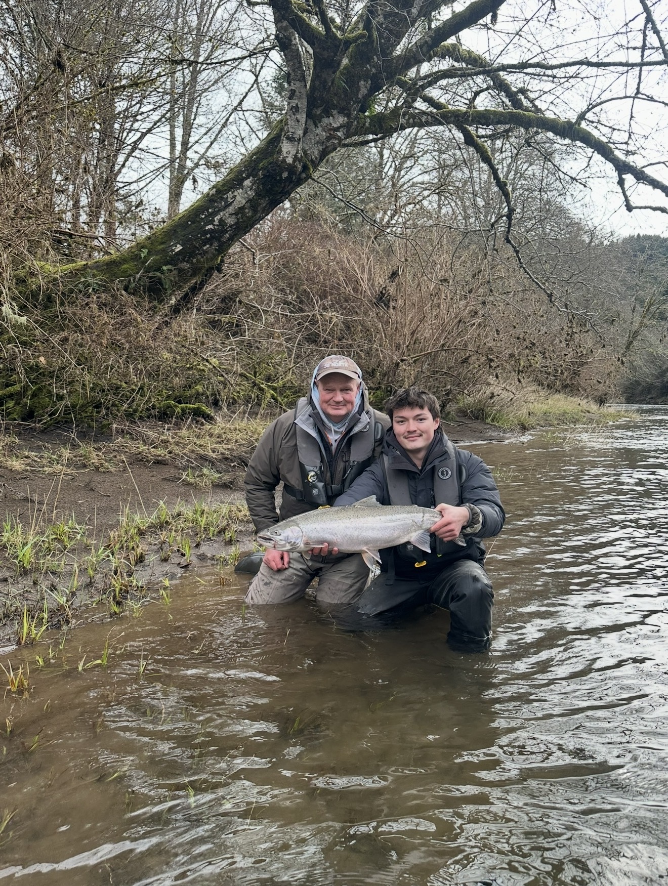 Captain Judd and client kneeling in the river with a huge chrome winter steelhead