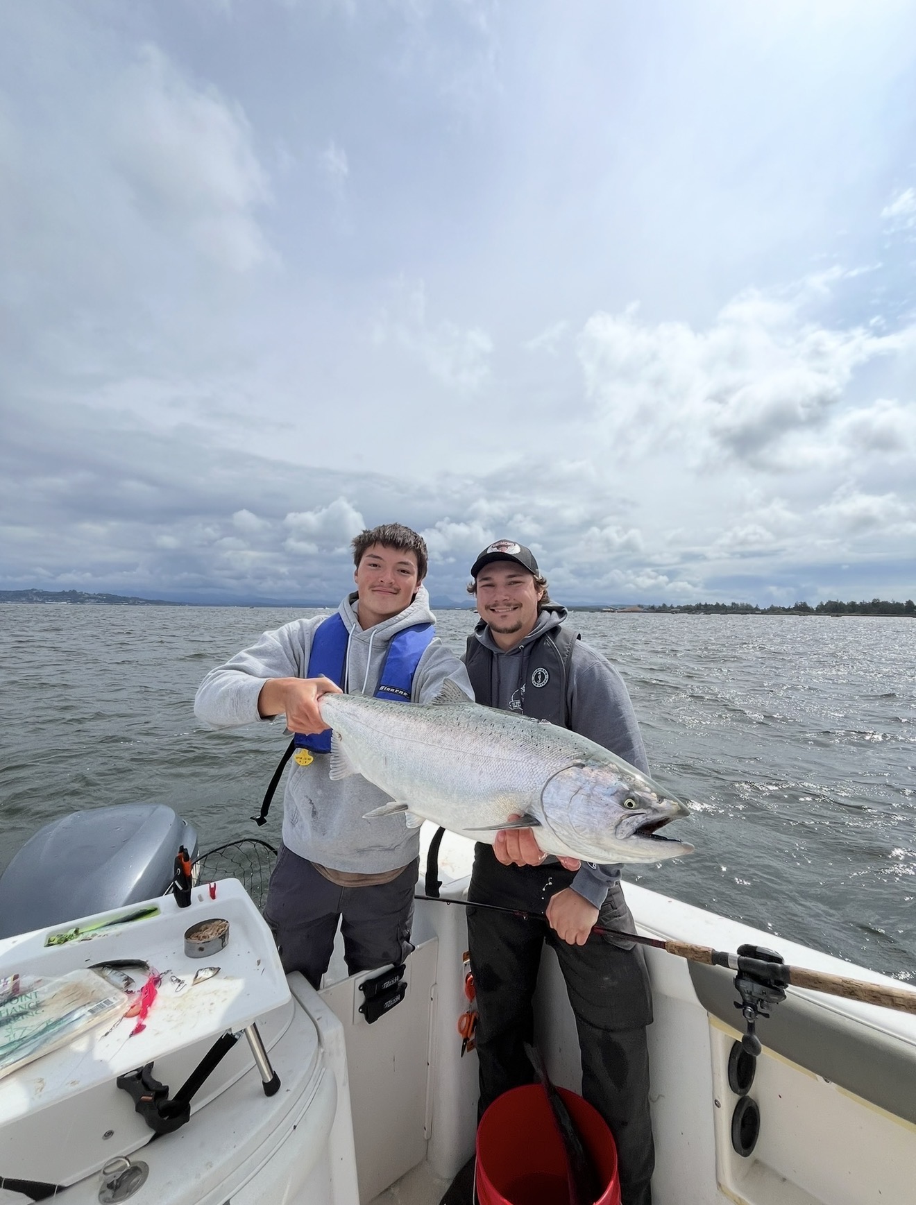 Captain Judd and a client holding a large Chinook salmon on the boat